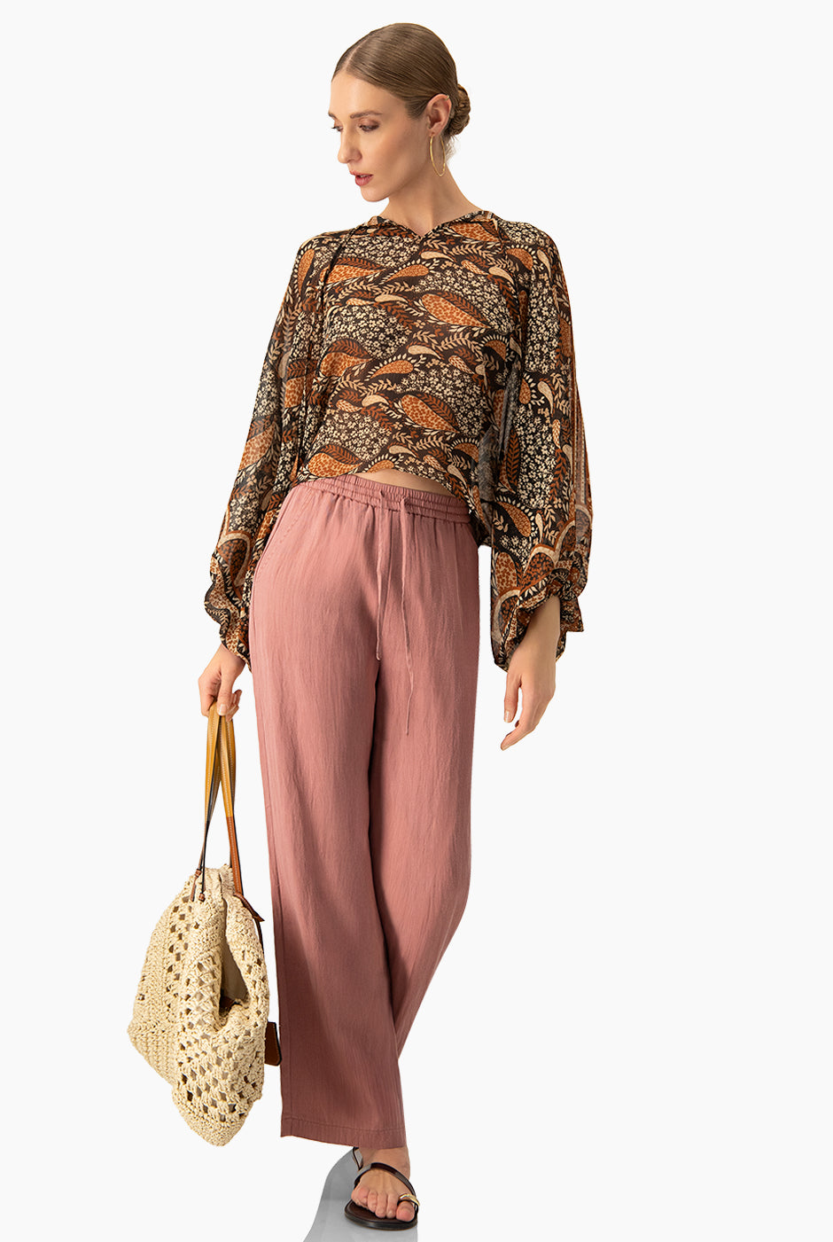Blusa estampada café con cintas en cuello y mangas murciélago.