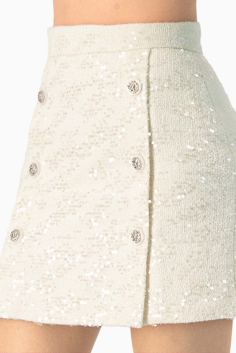 Falda corta marfil con botones y lentejuelas, vista frontal.