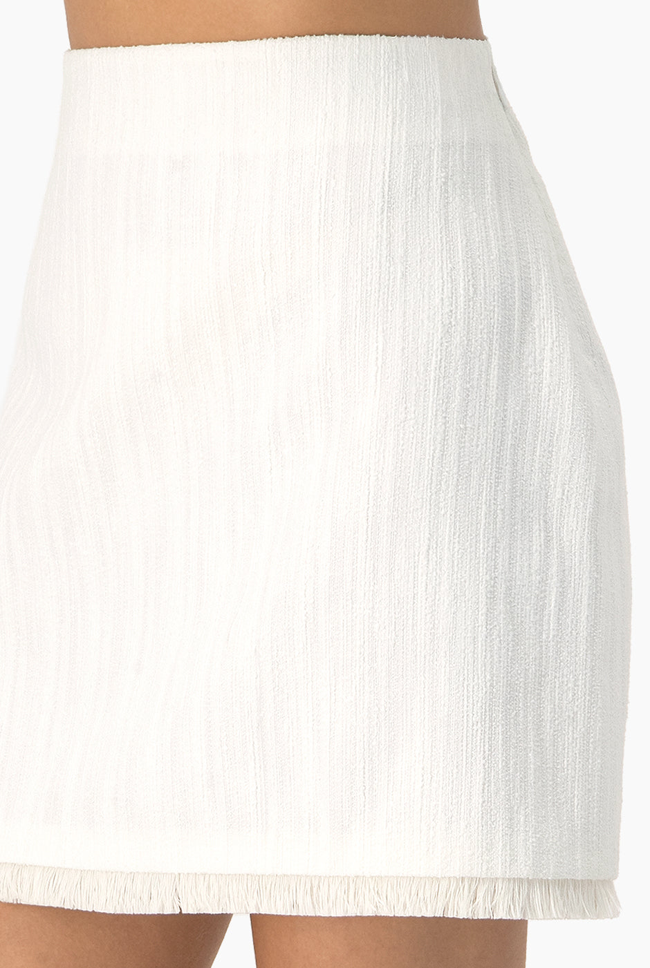 Falda tejida corta marfil con flecos, cierre lateral