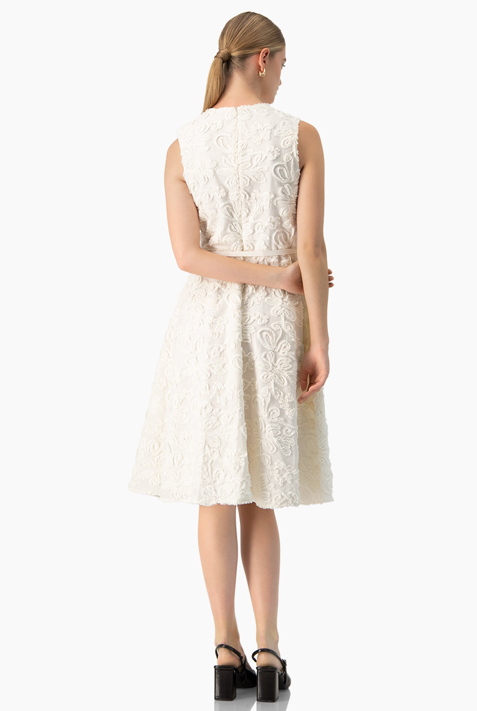 Vestido midi marfil sin mangas con cinturón y textura floral.