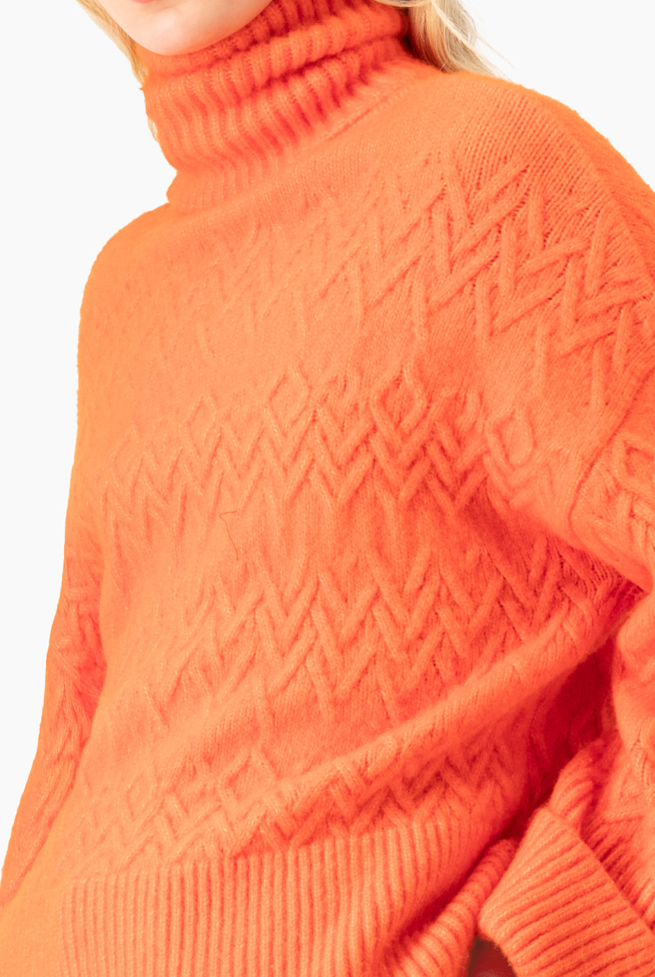 Suéter tejido oversized naranja con cuello tortuga y patrón geométrico