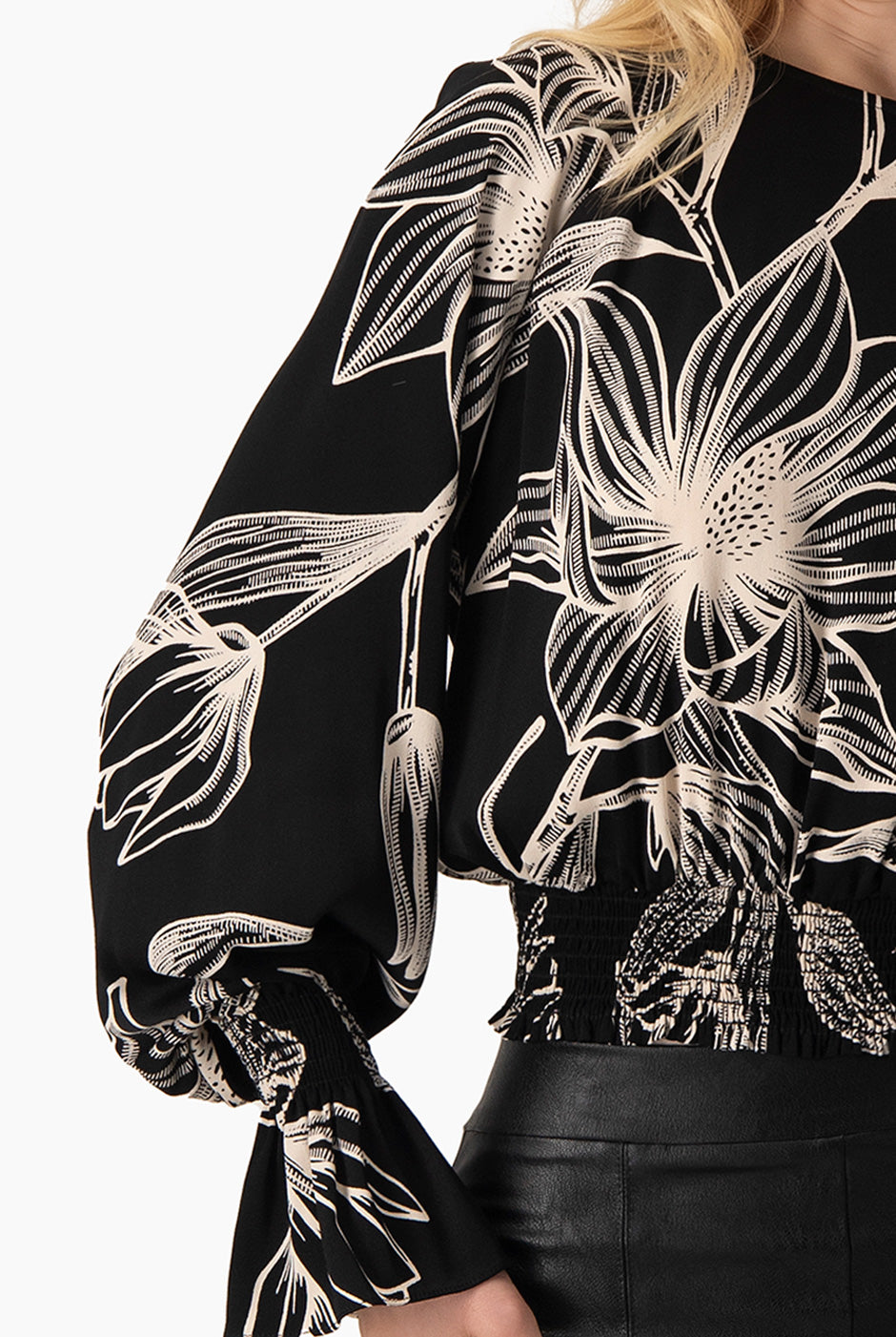 Blusa negra con estampado floral y smock