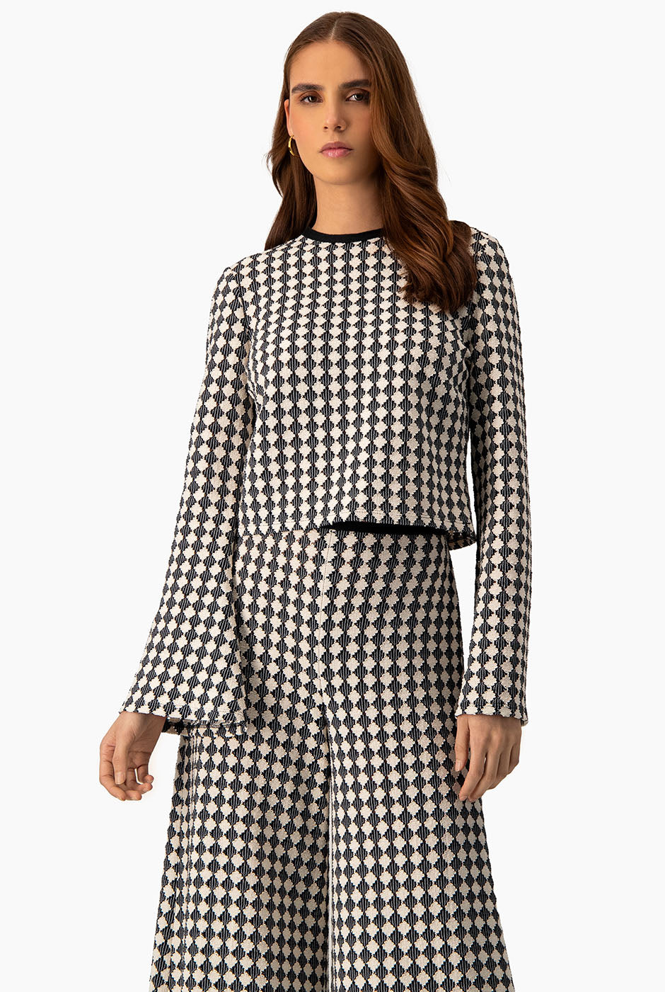 Blusa tejida natural con mangas acampanadas y patrón geométrico.