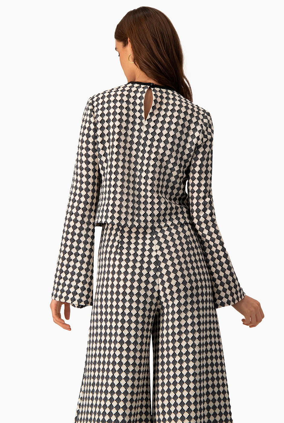 Blusa tejida natural con mangas acampanadas y patrón geométrico.