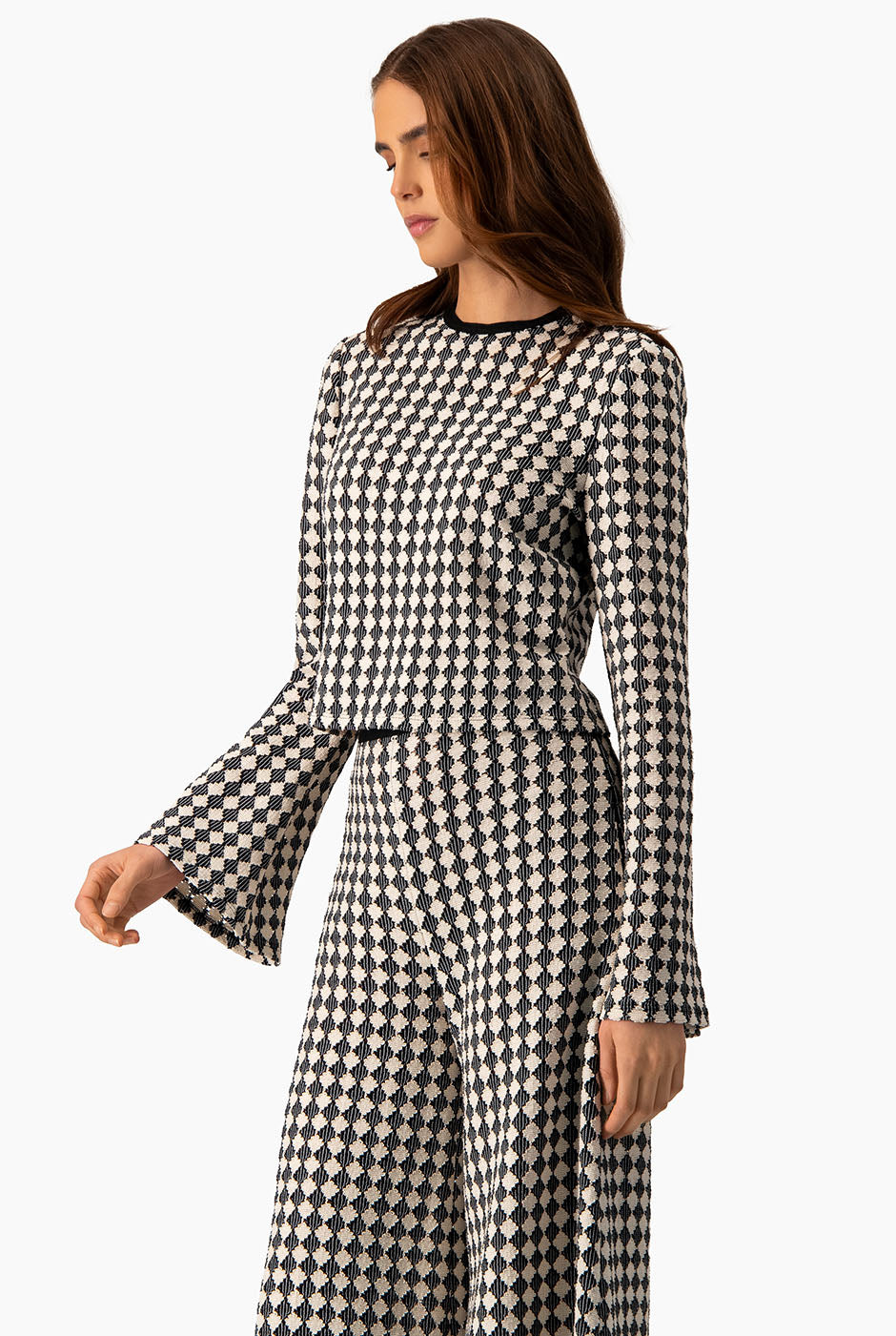 Blusa tejida natural con mangas acampanadas y patrón geométrico.