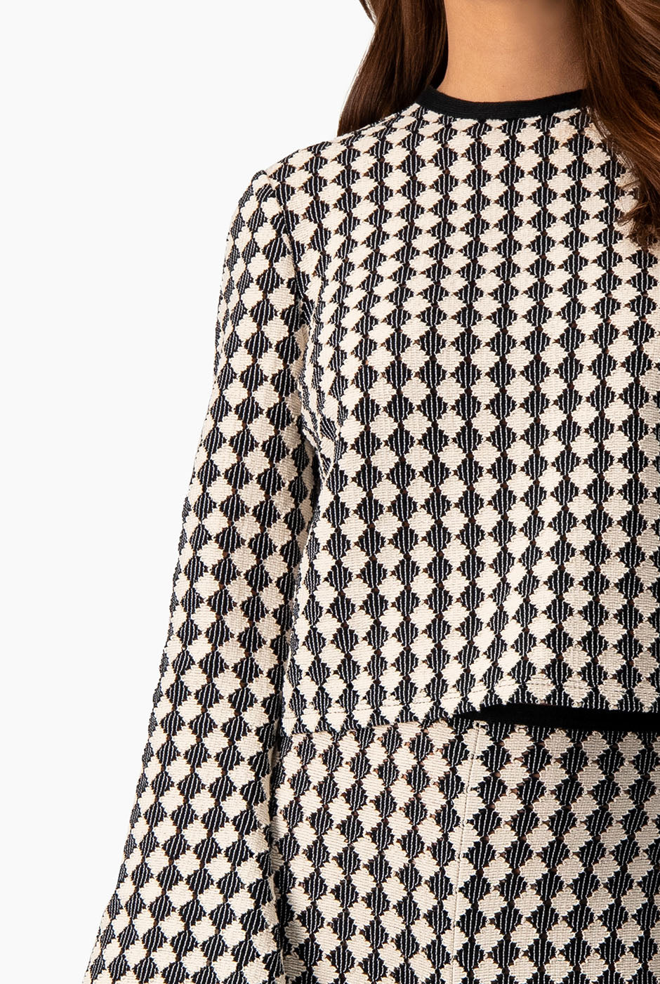 Blusa tejida natural con mangas acampanadas y patrón geométrico.