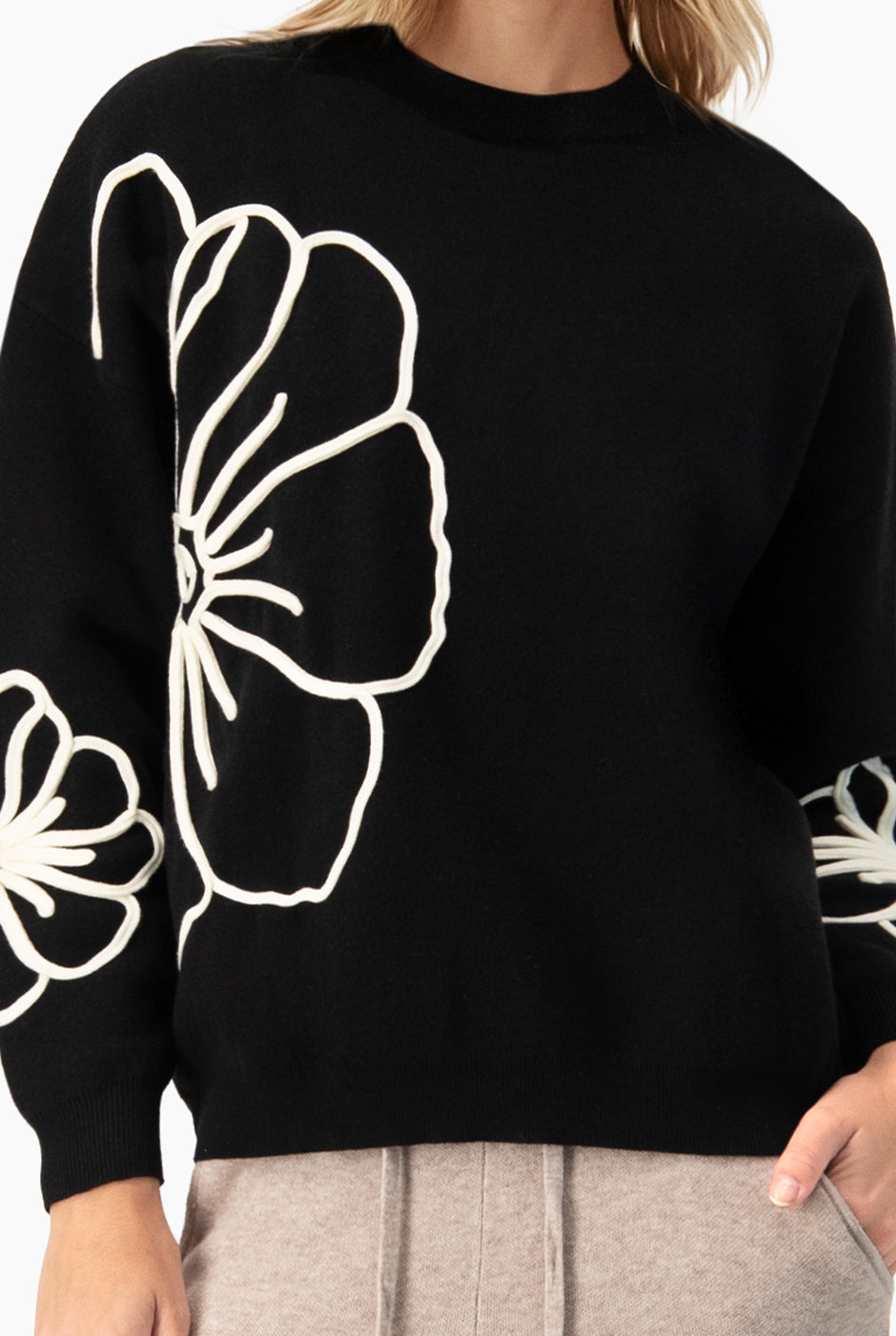 Pullover negro con cinta decorativa en contraste y estampado floral