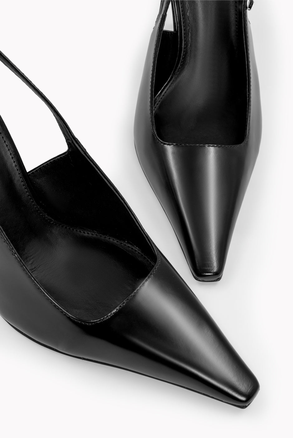 Zapatilla de cuero negro con tacón dorado y punta elegante